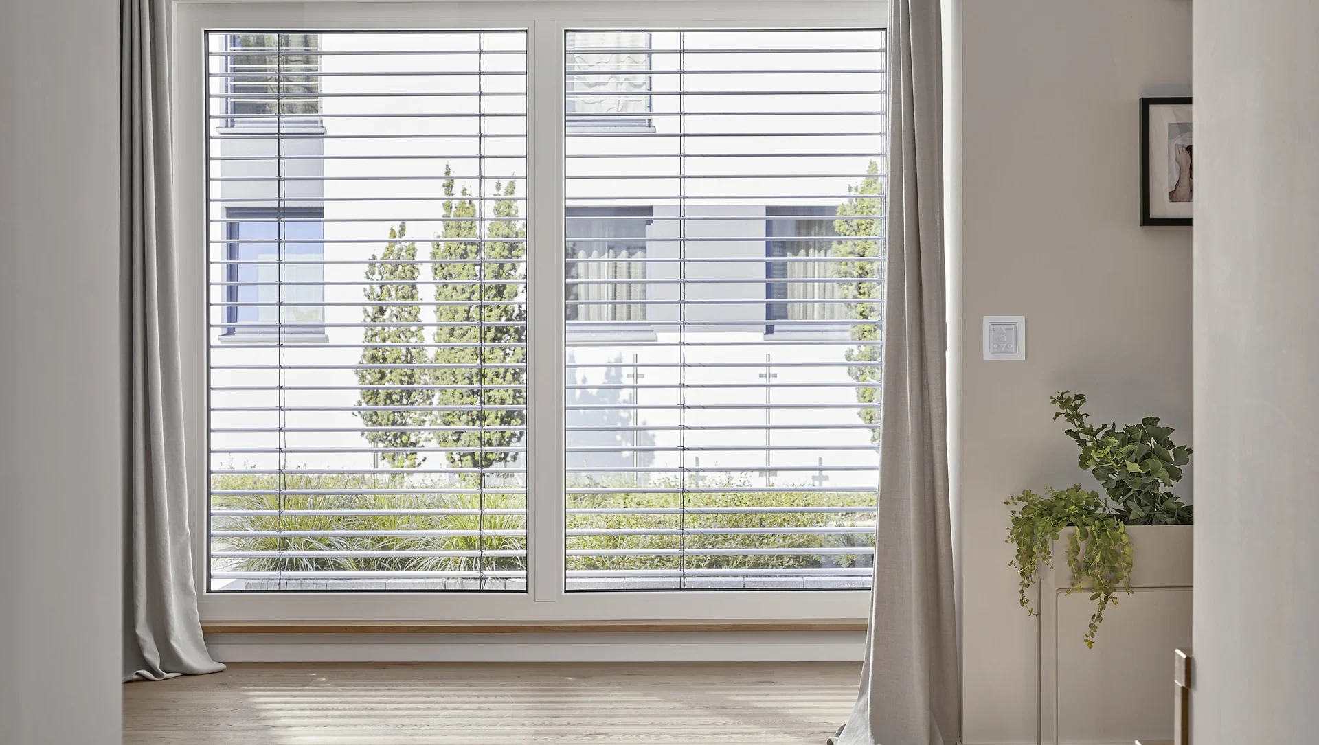 Moderne Innenansicht eines Raumes mit großen Fenstern und stilvollen Vorhängen