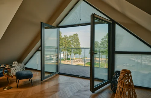 Modernes Wohnzimmer mit gelbem Sessel und Holztisch vor großen Fenstern